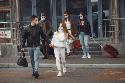 people with face masks leaving the airport