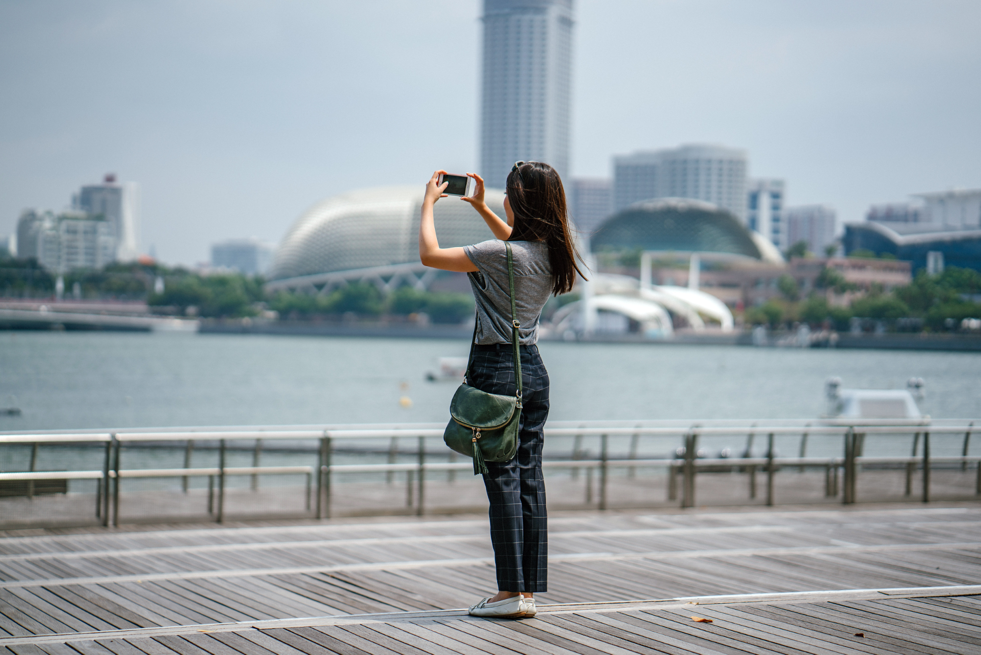 a picture of a tourist woman taking a photo of the city