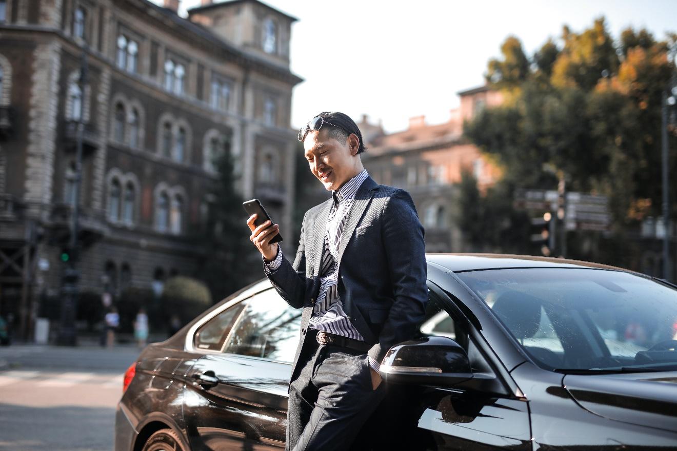 Man standing by a black luxury sedan