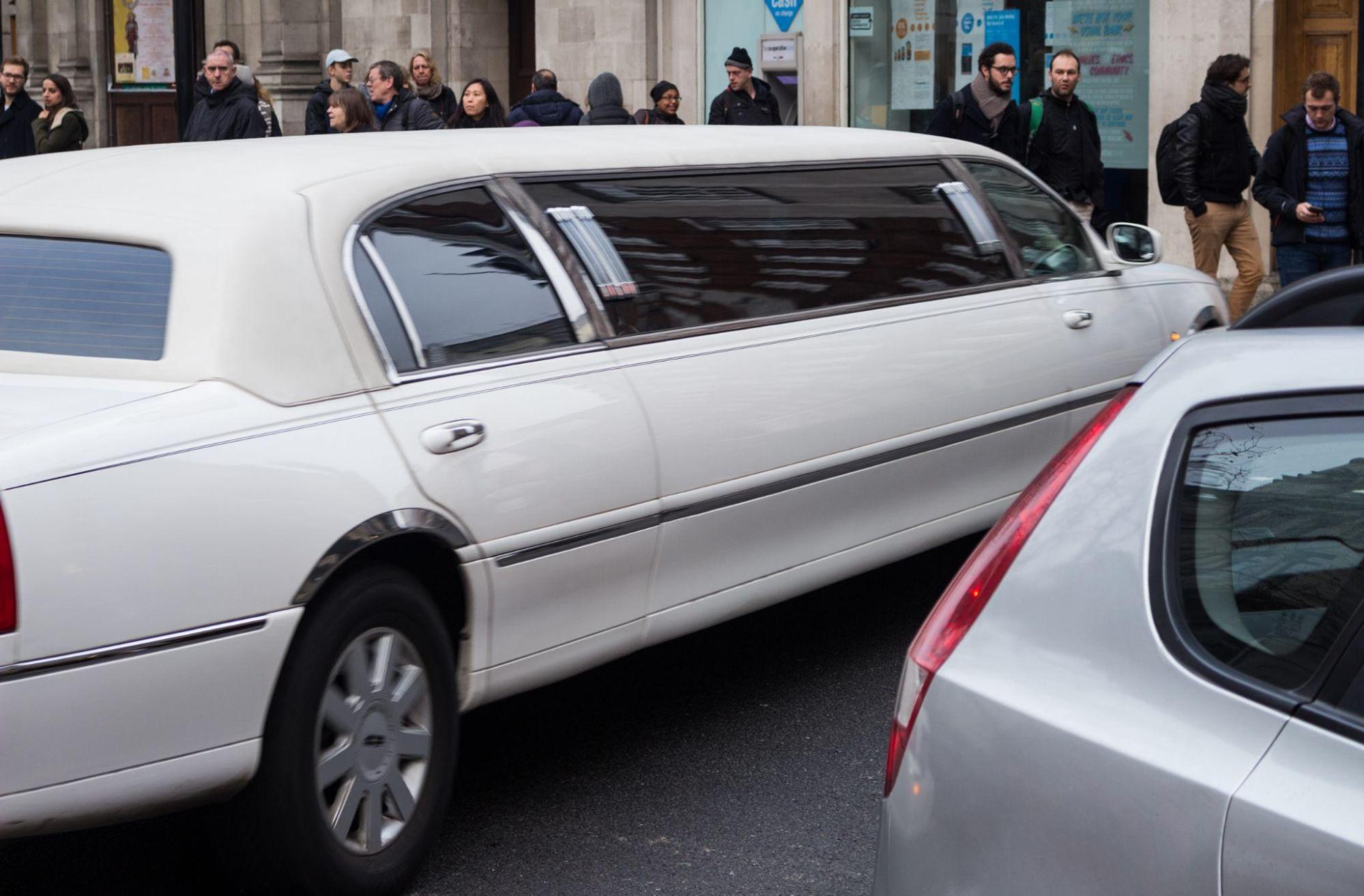 A white limousine parked outside a building