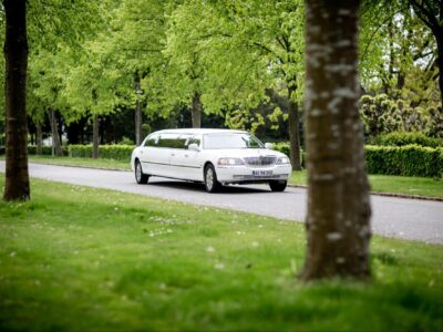 A white limo service car on a road